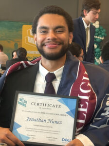 Student holding plaque and with FDU banner around his shoulders
