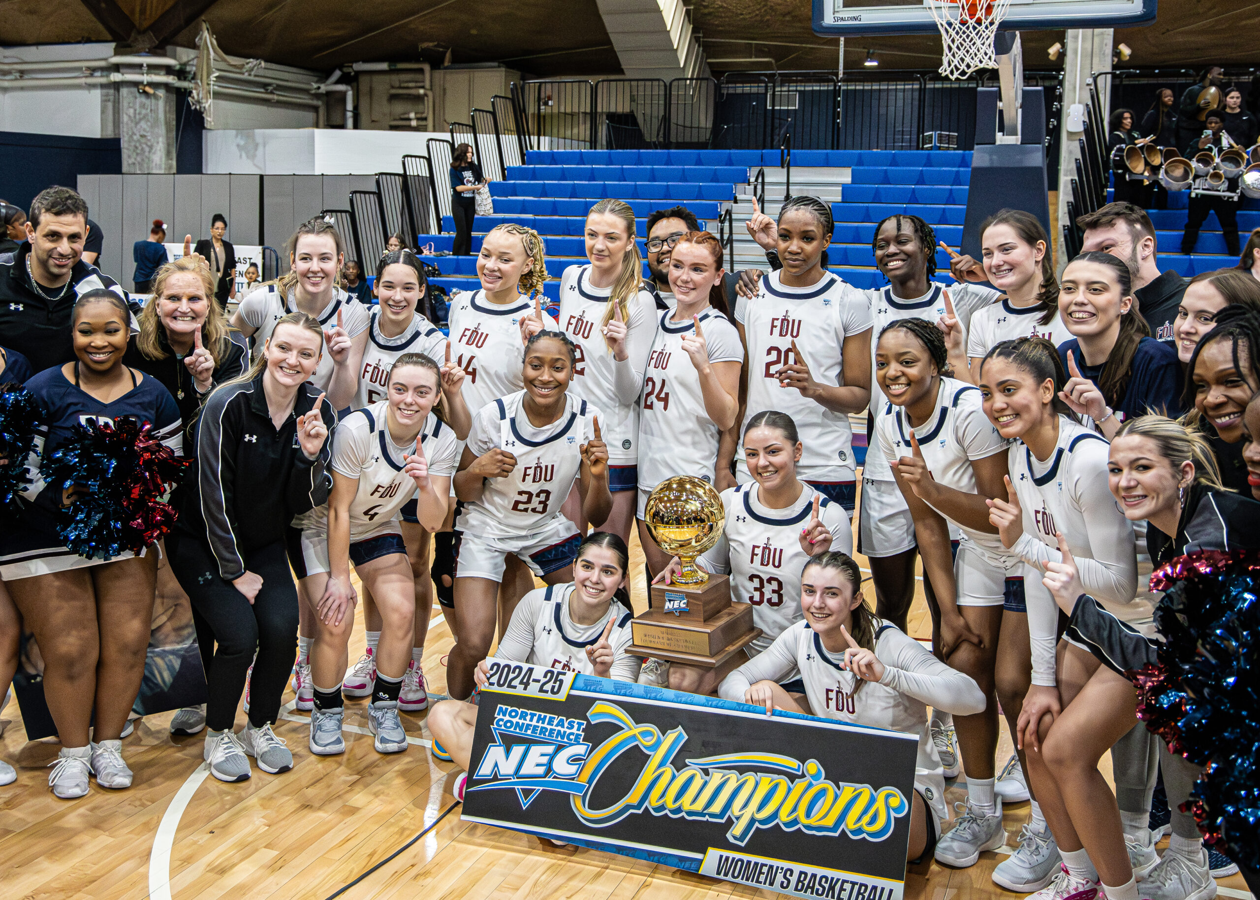 FDU Knights women's basketball team poses for a photo. They hold up a trophy and a sign reads "NEC Champions."