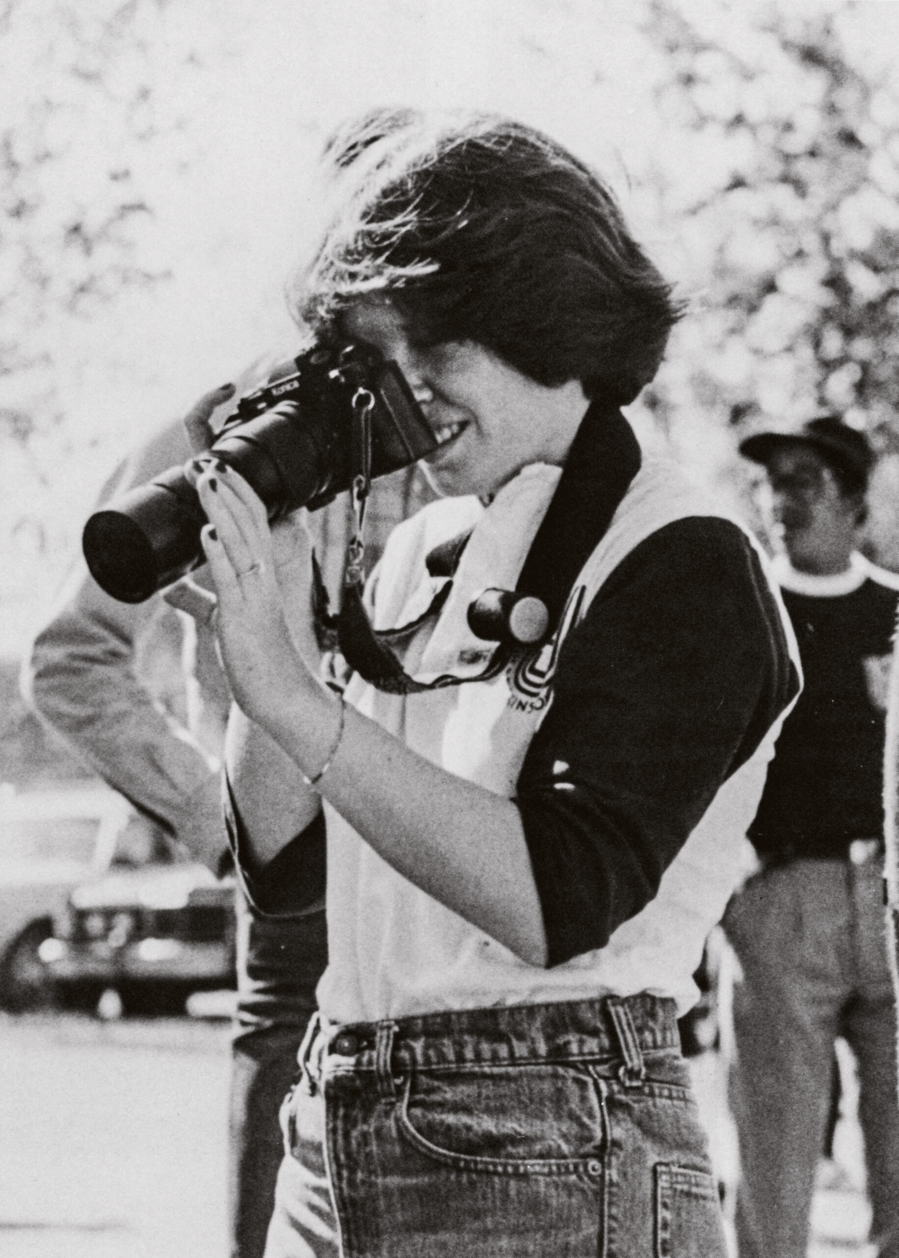 A student adjusts the focus on a long lens camera.