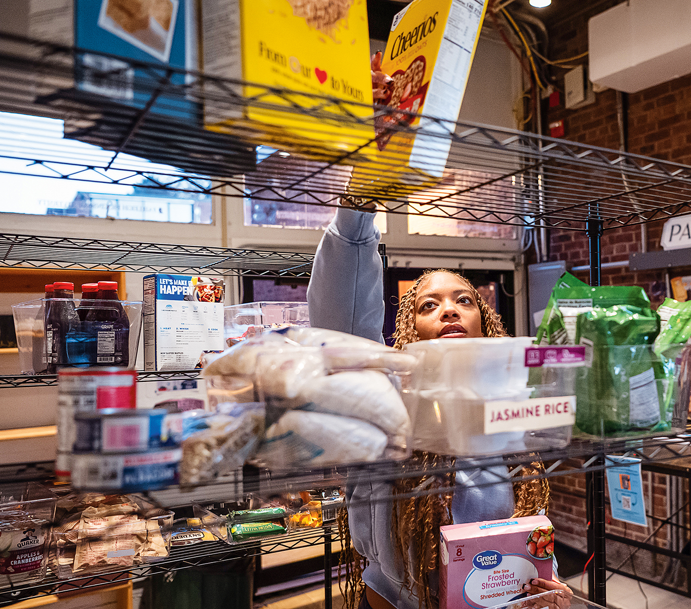 A woman stocks the shelves of a food pantry.