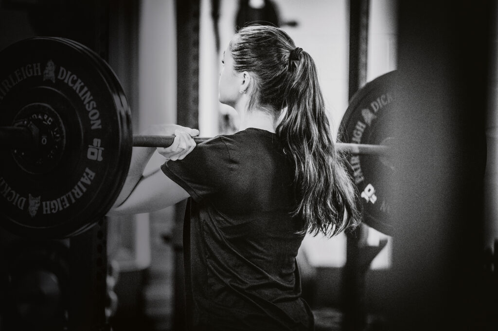 A woman lifts weights in a gym.
