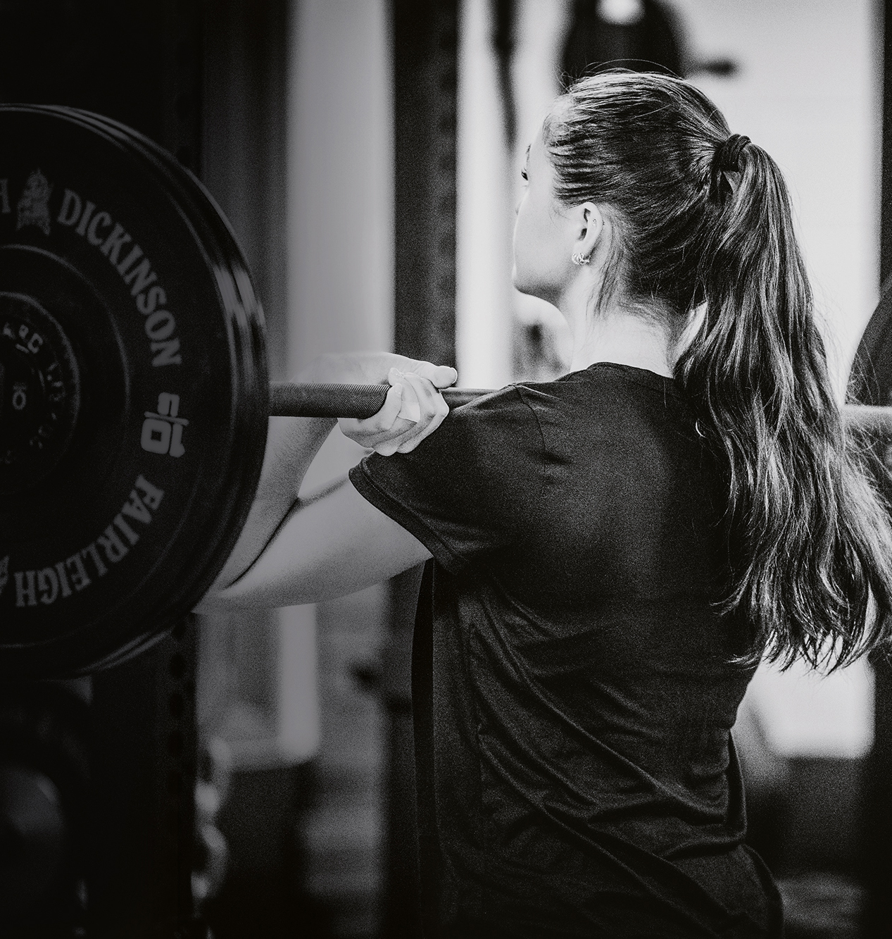 A woman lifts weights at the gym.