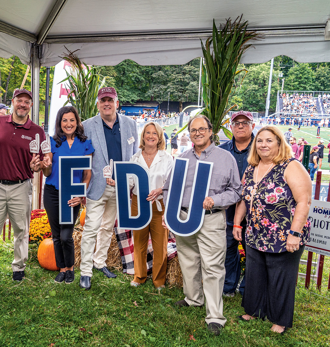 A group of alumni hold up F-D-U letters at Homecoming.