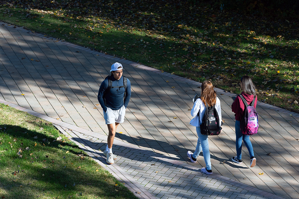 Students walk on campus on a fall day.