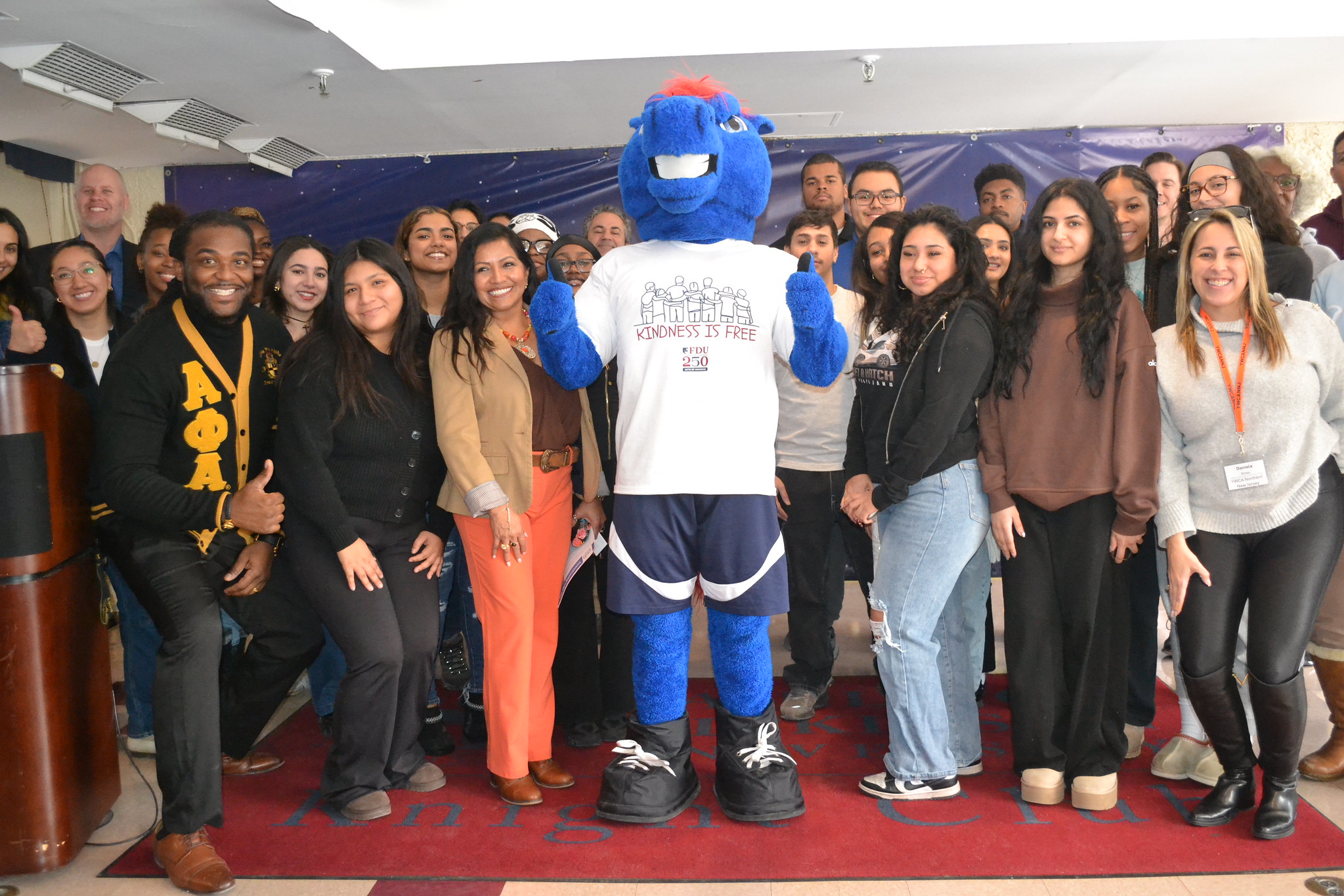 a large group poses with Knightro the mascot for a photo.