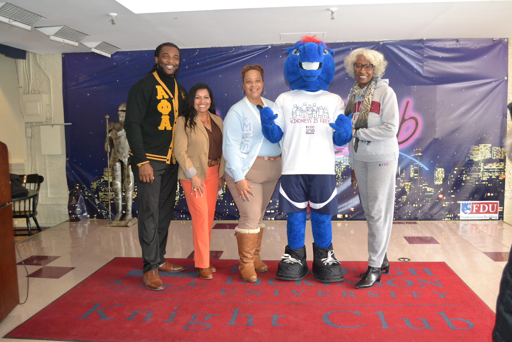 a group poses with Knightro the mascot for a photo.