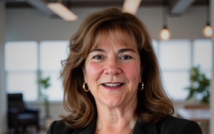 headshot of a woman. she crosses her arms and wears a blazer.