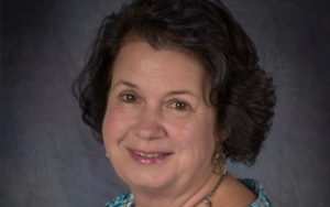 headshot of a woman. she wears a blue blouse.
