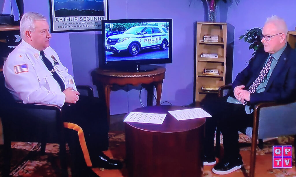 Two men seated in an interview. Man on the left is a police chief.