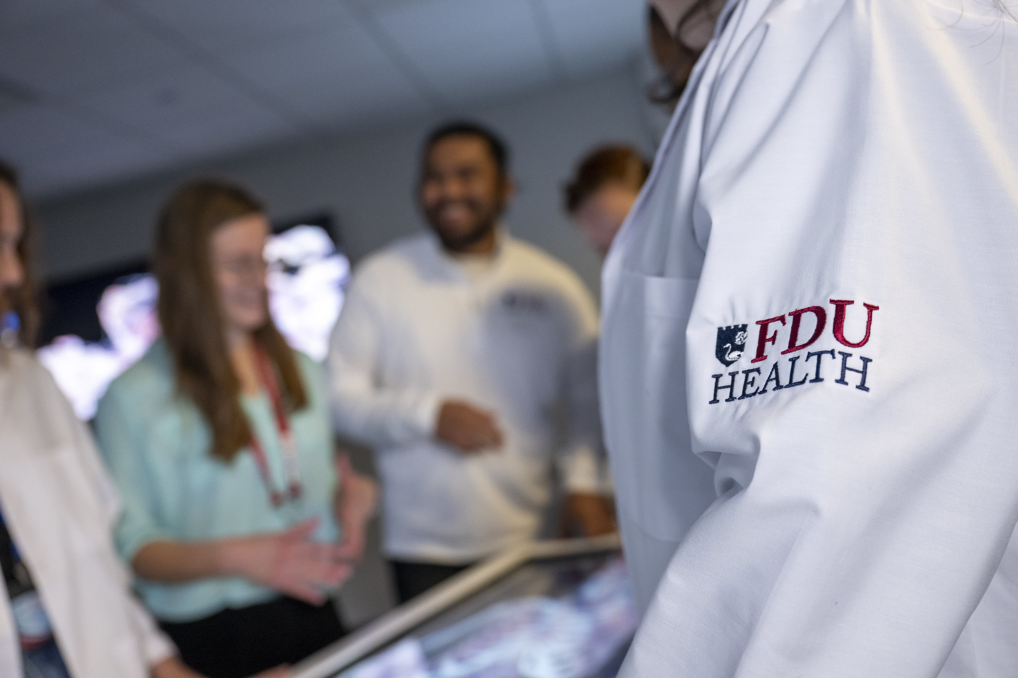 A close-up image of the FDU Health-branded white coats.