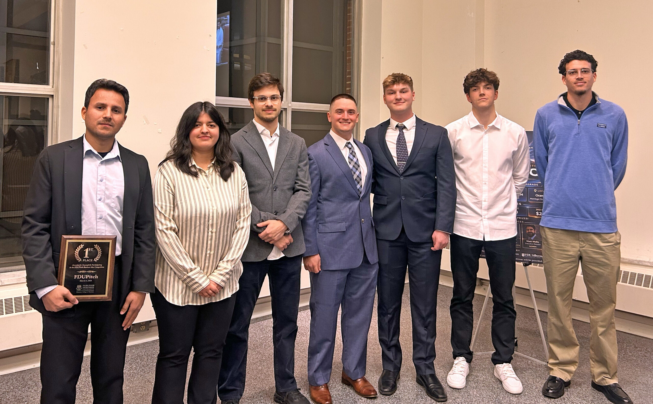 Six male students and one female student pose for a photo.