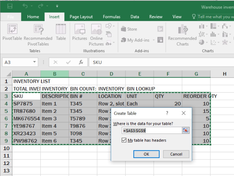 Microsoft Excel window displaying the Create Table dialog box over an inventory spreadsheet. The dialog box specifies the data range as =$A$3:$G$9 and has the "My table has headers" checkbox selected. The selected range in the background is outlined with a green dashed border and includes columns for SKU, Description, Bin #, Location, Unit, Qty, and Reorder Qty. The Insert tab is active in the ribbon menu.