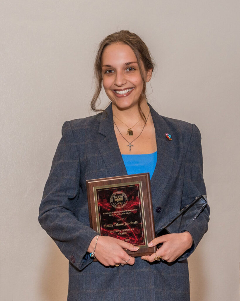 A young woman holds up a plaque.