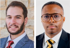 Two smiling men wearing suits: the one on the left has a beard and the one on the right is wearing glasses