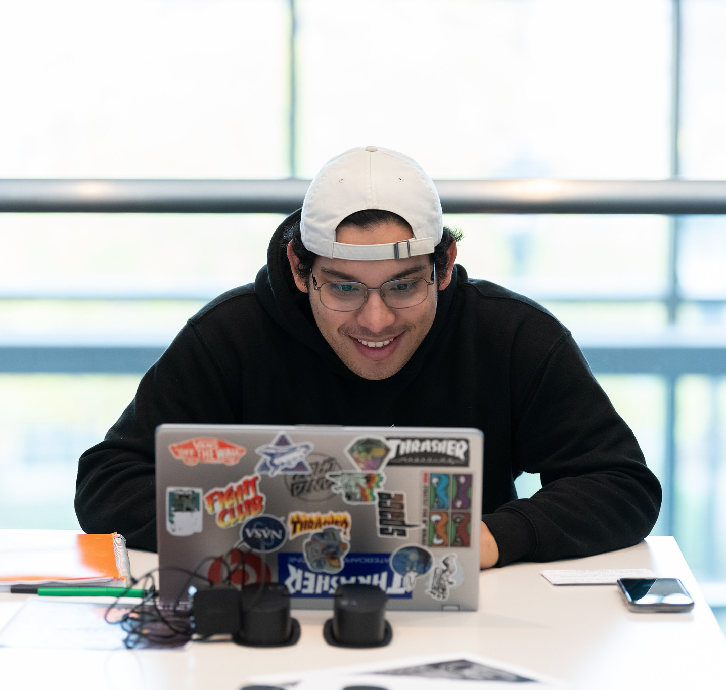 A young man works on his laptop in the library.