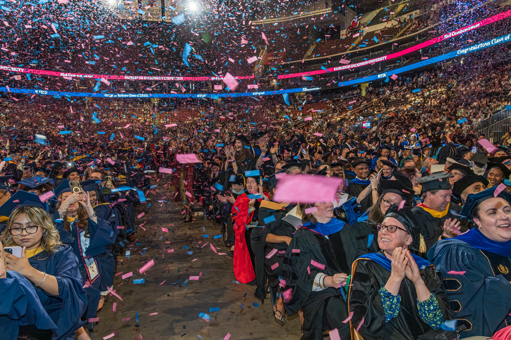 A crowd of graduates is covered in confetti.