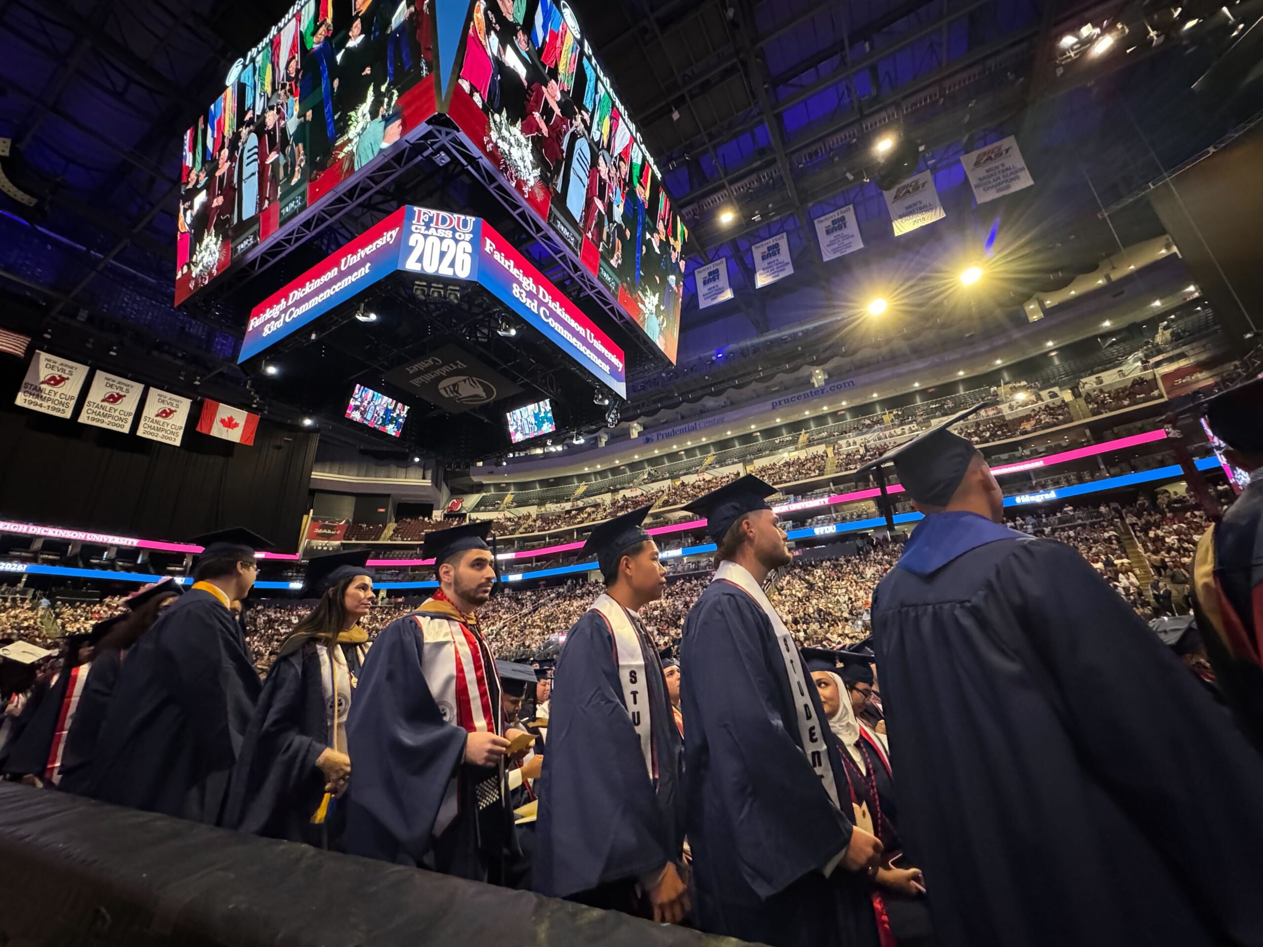 Students in caps and gowns line up at graduation.