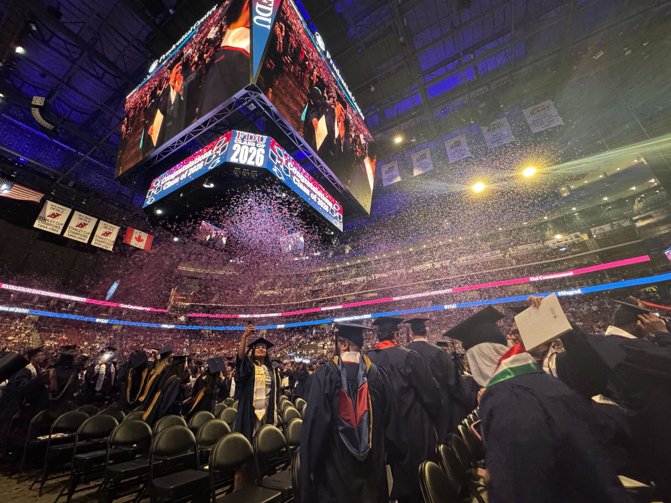 A crowd of graduates is covered in confetti.