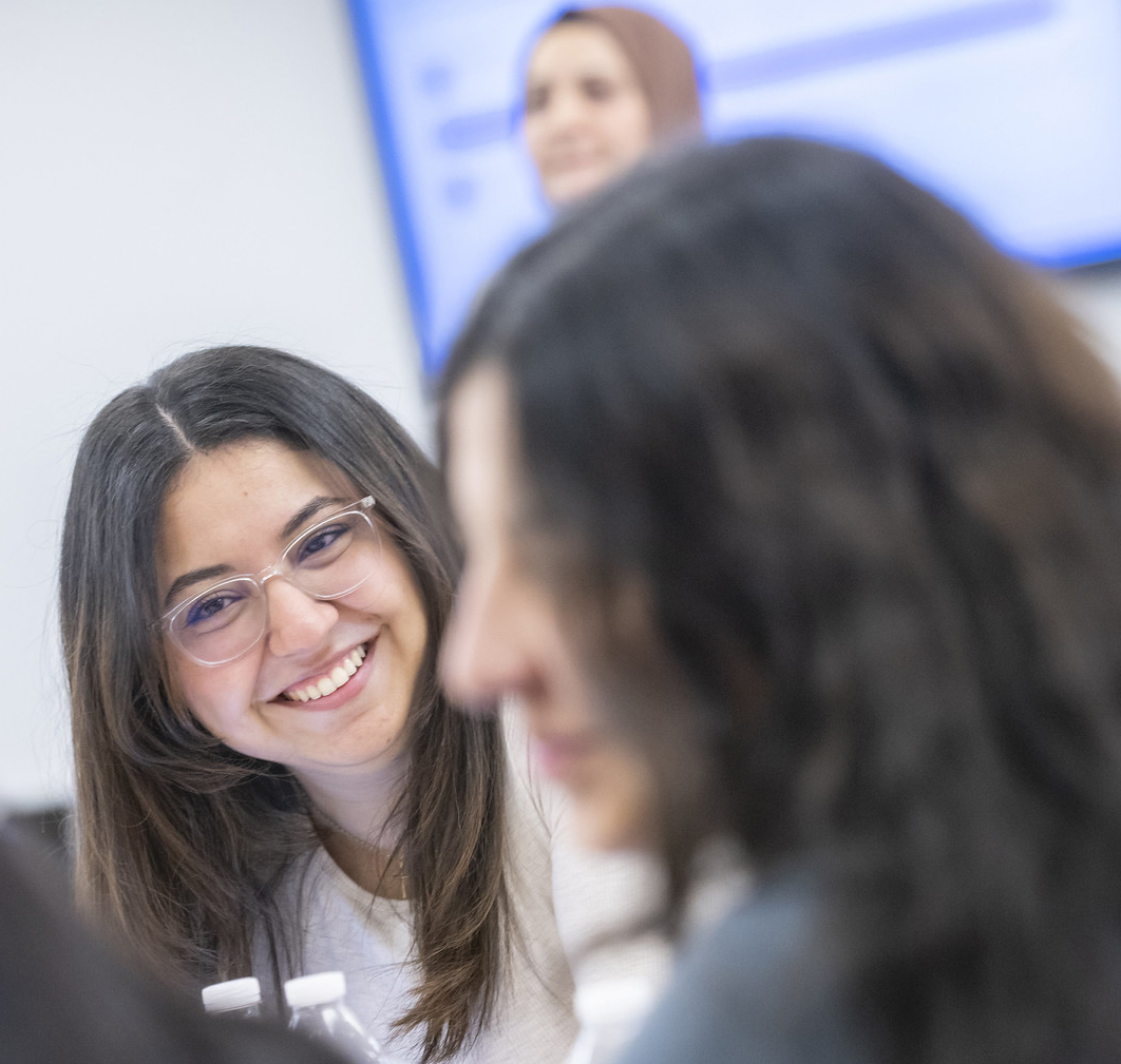 Two women smile in class.