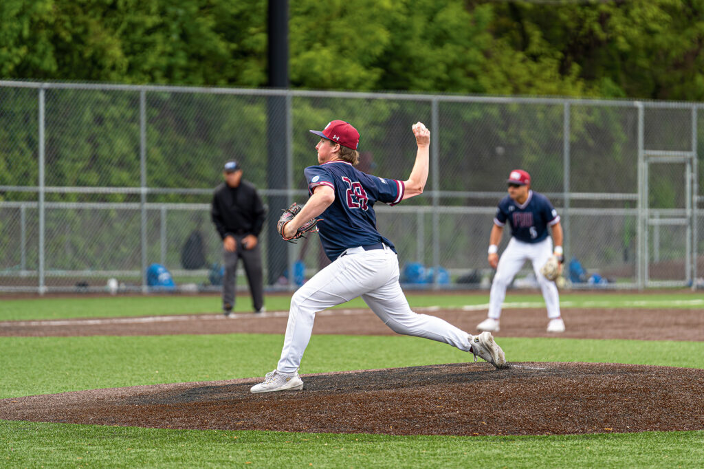 A baseball pitcher winds up to throw a pitch on the mound.