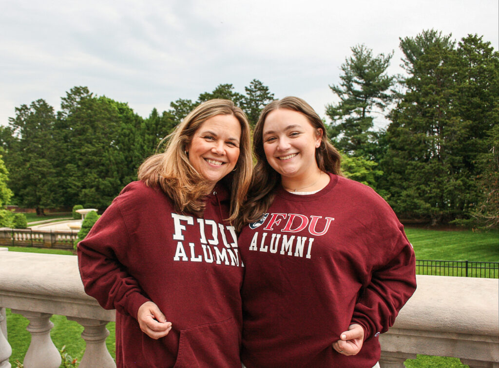 Two women stand together in burgundy FDU sweatshirts at the Florham Campus.