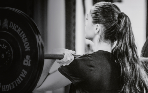 A woman lifts weights at the gym.