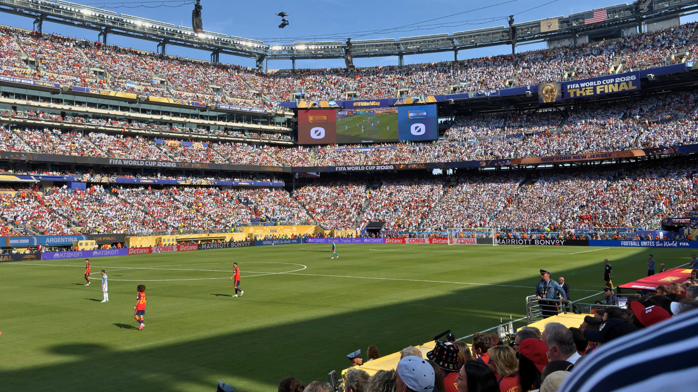 New York New Jersey Stadium during the World Cup Final match. the stadium is filled with fans. two soccer teams play on the pitch.