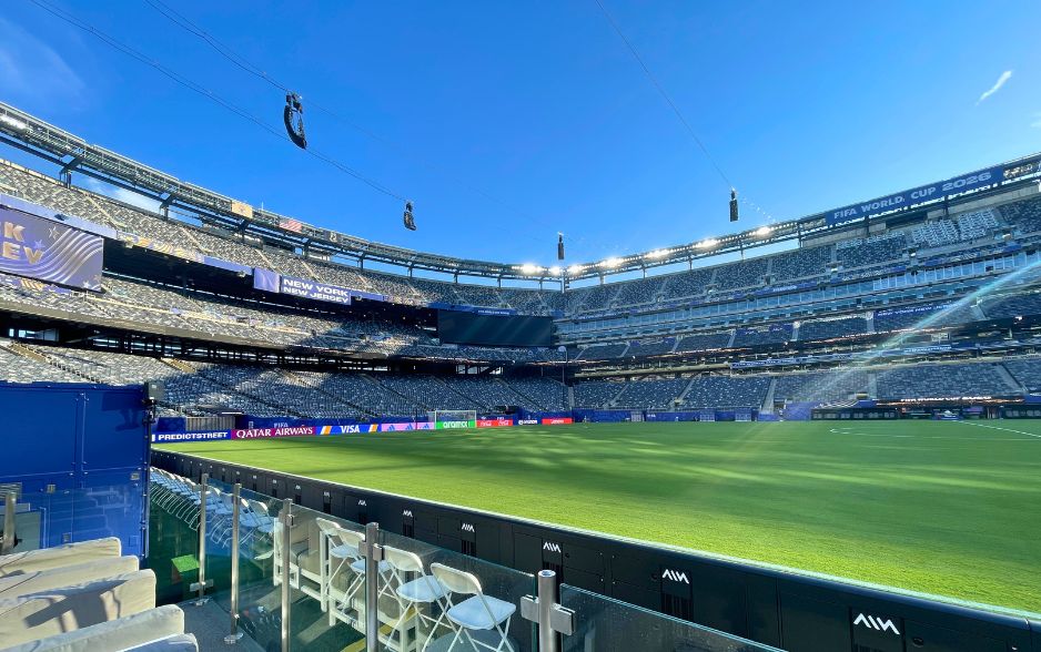 a soccer stadium. signs read "new york new jersey" and "fifa world cup 2026"