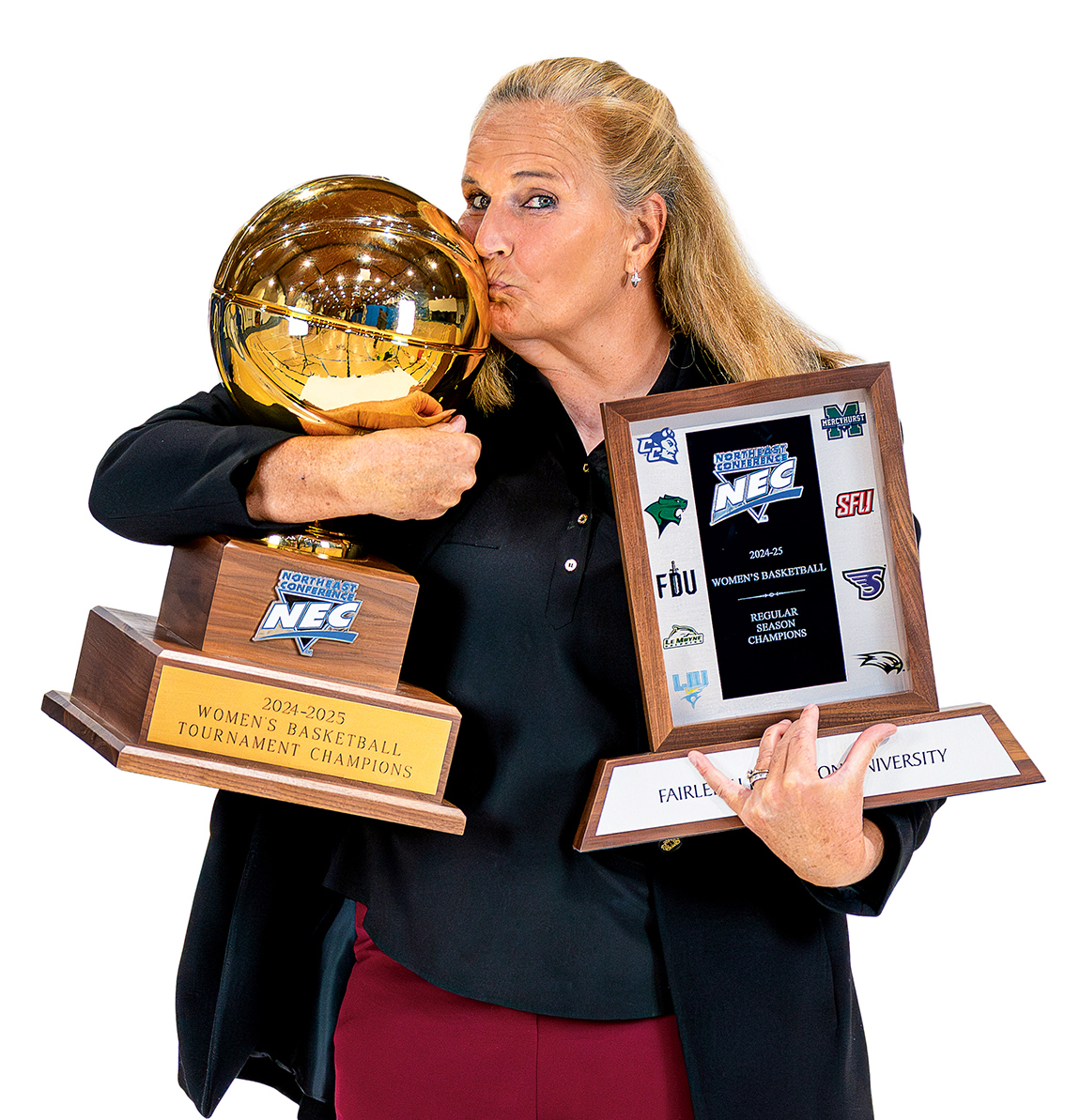 A woman holds two trophies and kisses one.