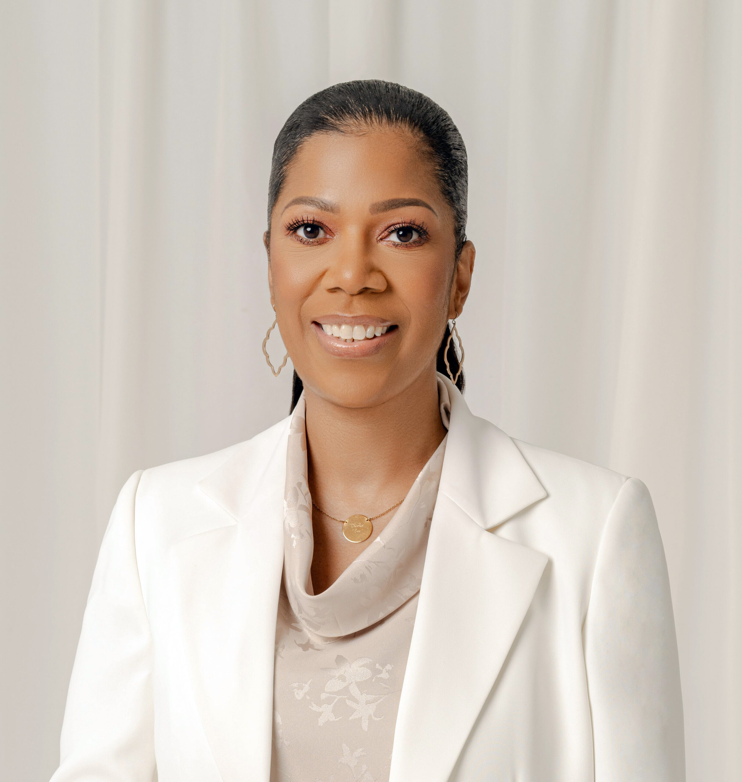 A portrait of a woman wearing an off-white blazer.