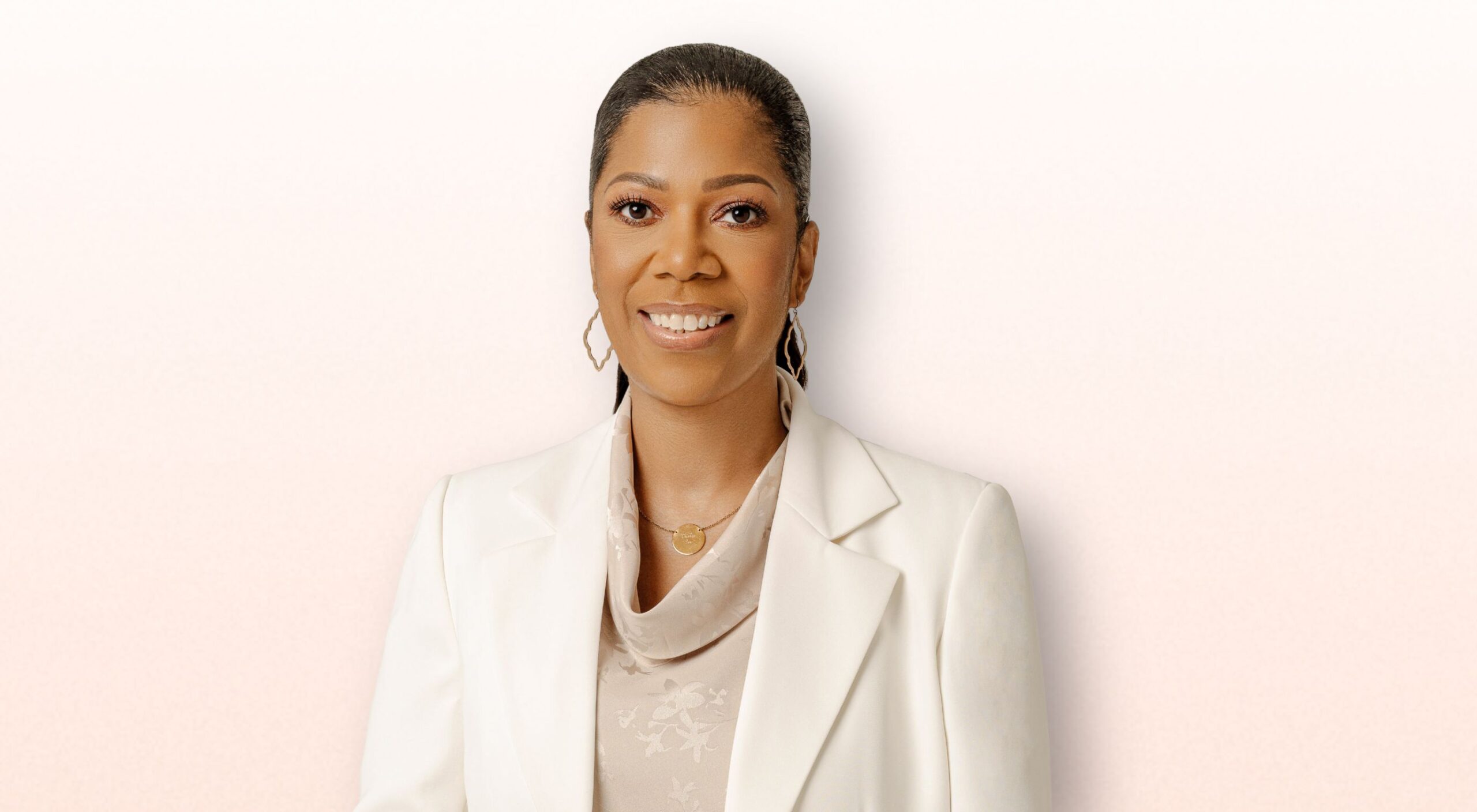 A portrait of a woman wearing an off-white blazer.