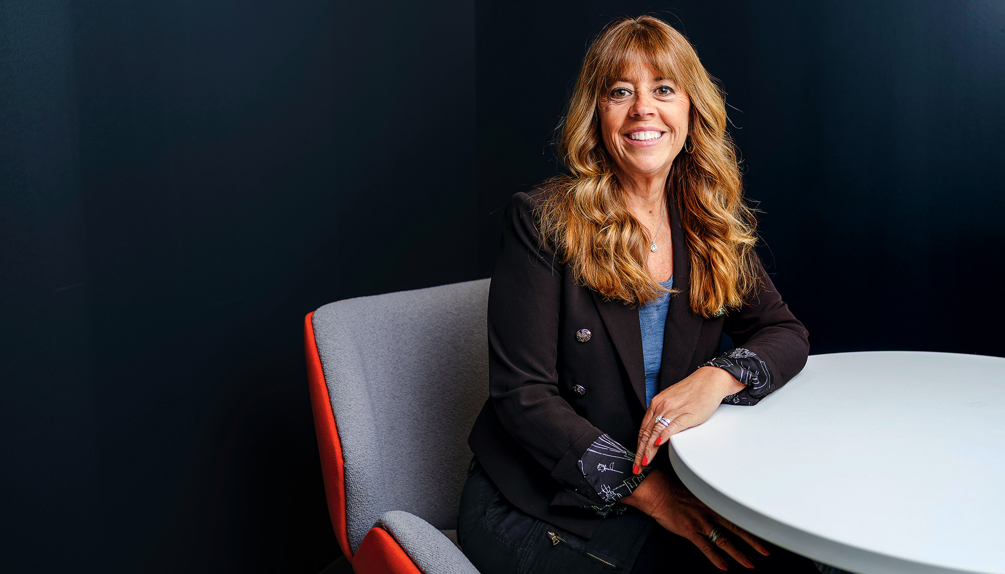 A woman sits in an office for a portrait.