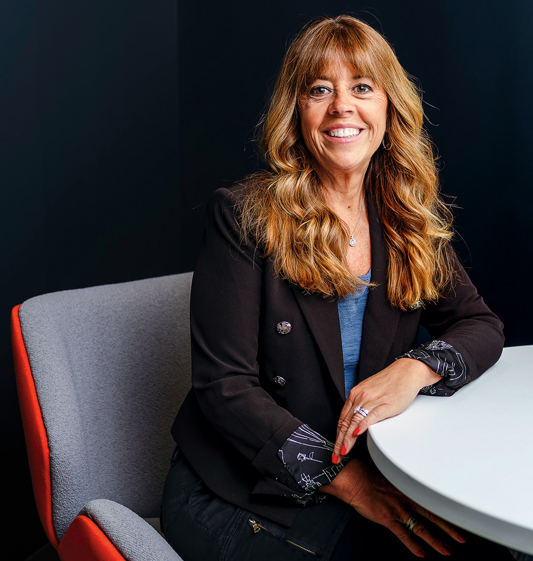 A woman sits in an office for a portrait.