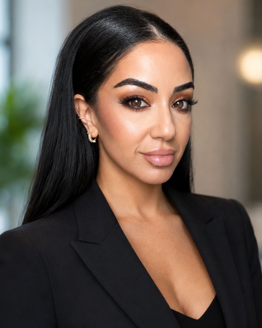 a headshot of a woman. she wears a black blazer.