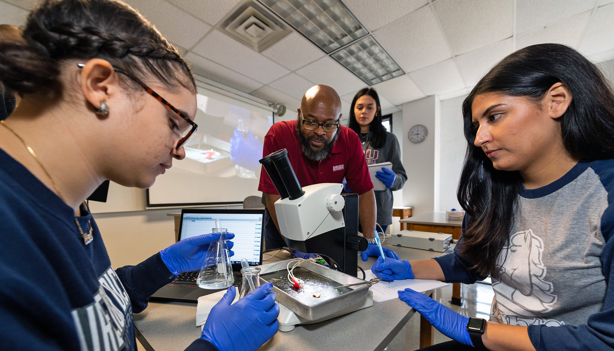 a professor and college students in a classroom lab.