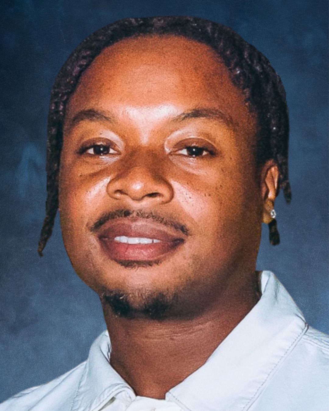 a headshot of a man. he wears a white button-down shirt.