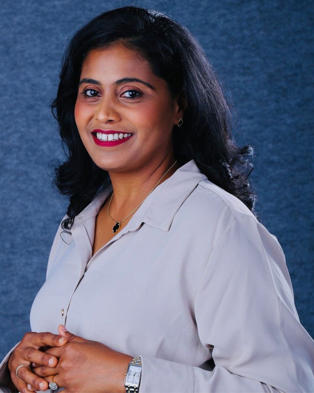 a headshot of a woman. she wears a light blue button-down shirt.