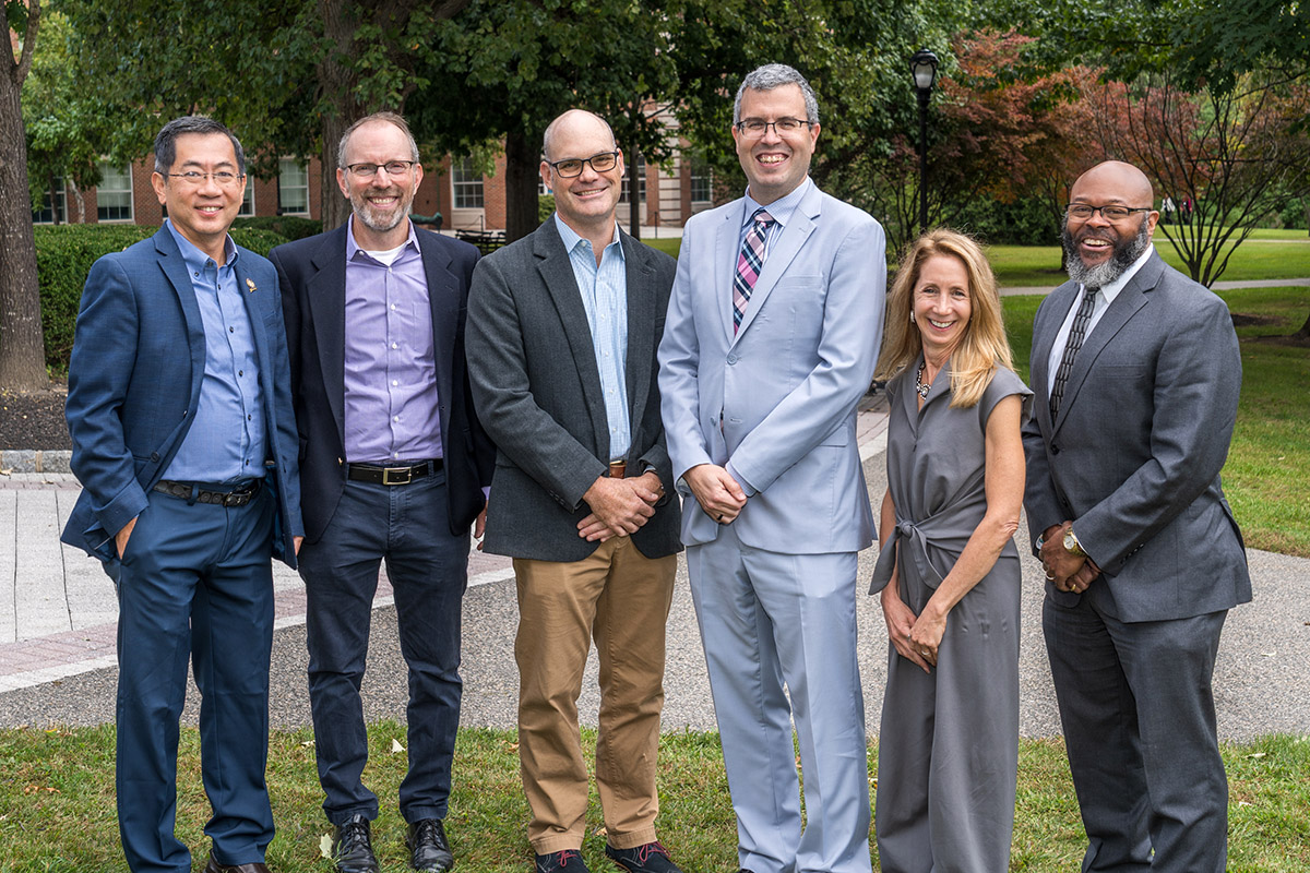 Six people pose for a group photo.
